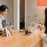 Customer ordering an iced drink at a bright unbranded cafe